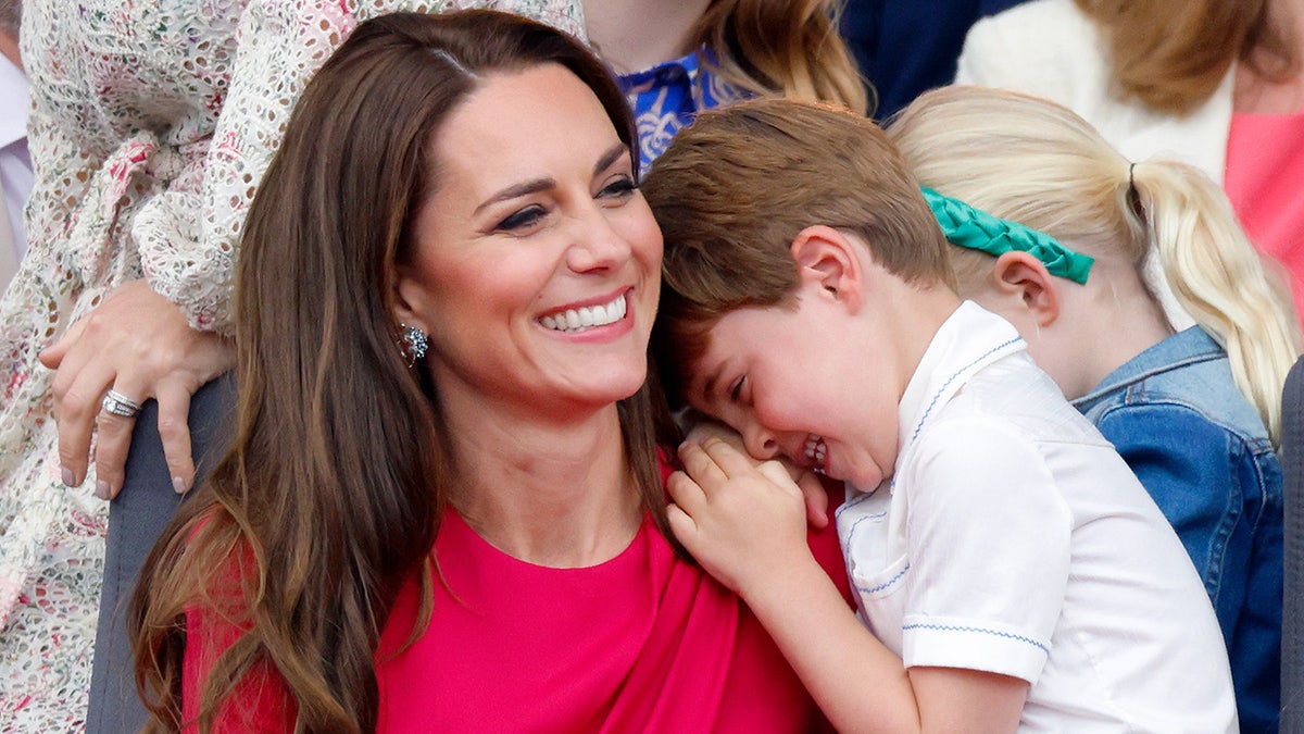 Kate Middleton smiling as Prince Louis leans on her shoulder laughing
