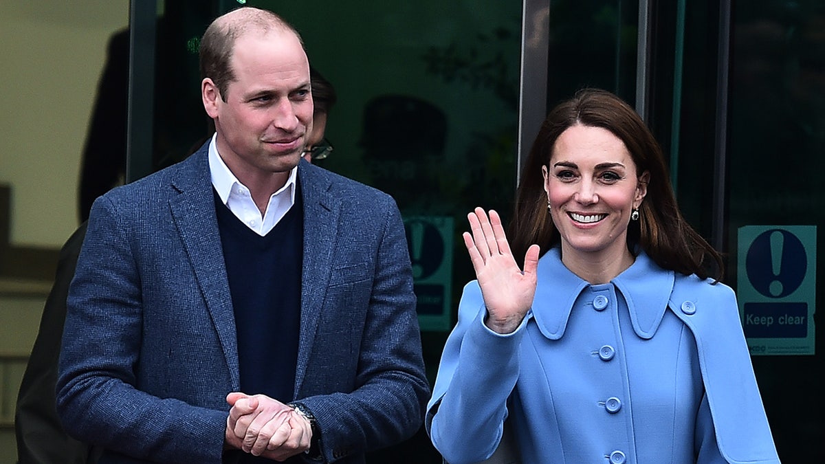 Kate Middleton waving as Prince William watches with his hands together
