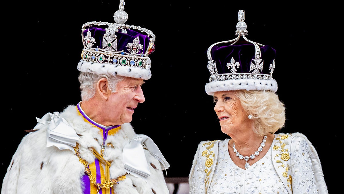 King Charles and Queen Camilla wearing crowns looking at each other.
