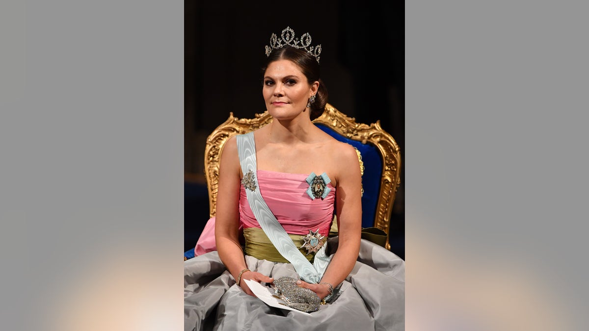 Crown Princess Victoria wearing a pink strapless gown with a white sash and a tiara