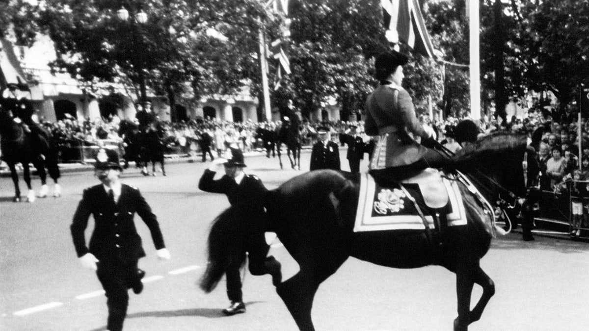 Queen Elizabeth riding on horseback as police rush over