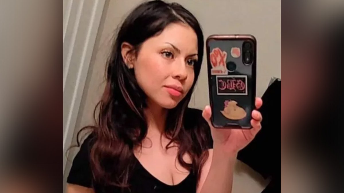 Giselle Salazar-Tapia holds phone for selfie.