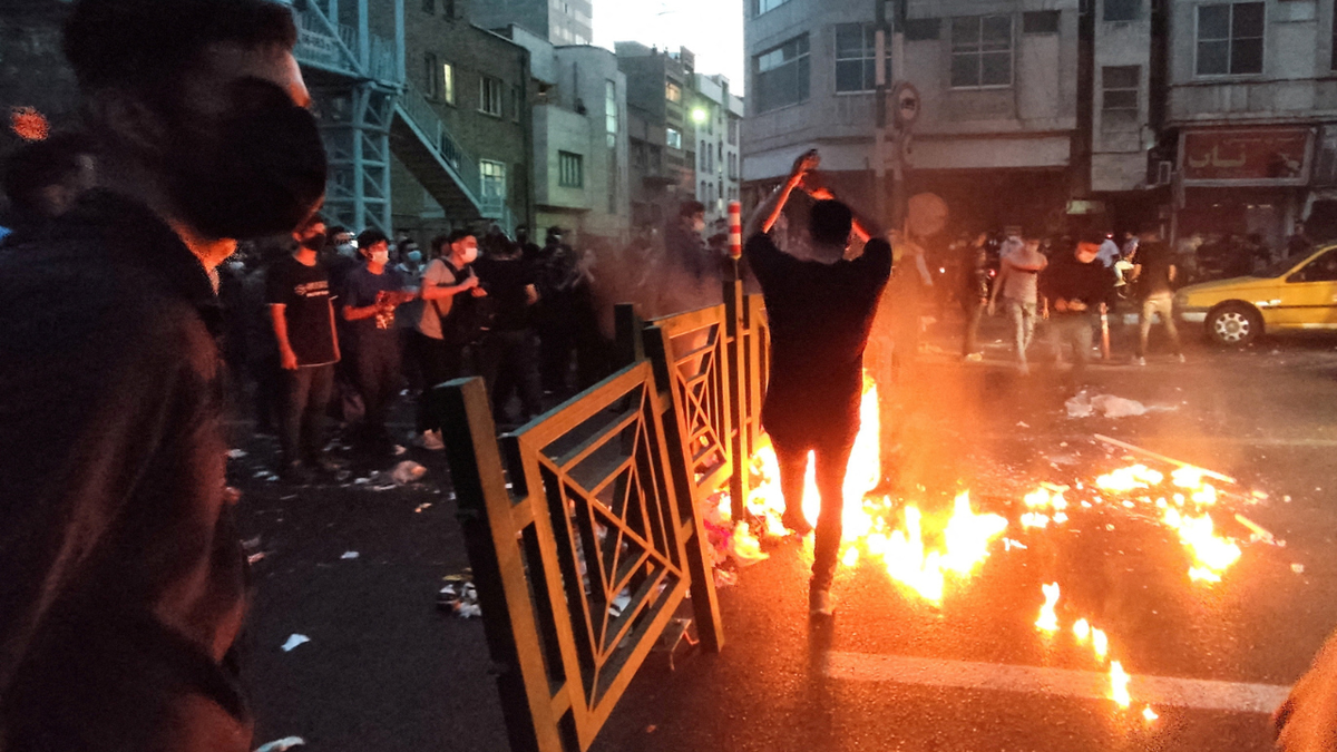 People light a fire during a protest