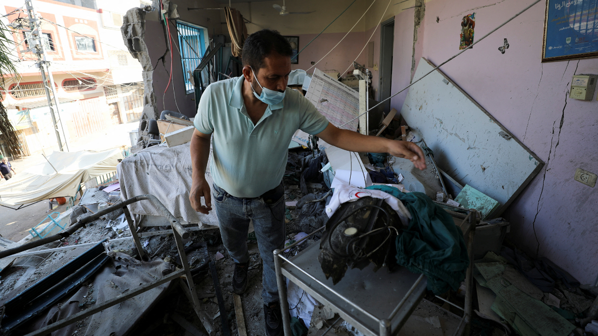 Palestinian inspects the damages at Al-Daraj clinic