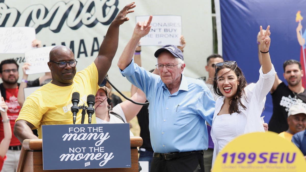 Rep. Jamaal Bowman of New York in yellow shirt on left with Bernie Sanders, AOC
