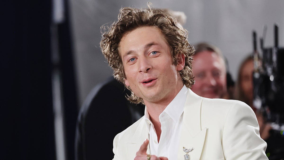 Jeremy Allen White smiling at camera on red carpet