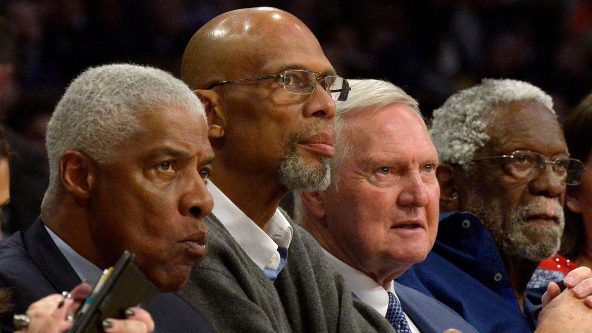 Julius Erving, Kareem Abdul-Jabaar, Jerry West and Bill Russell sit on bench
