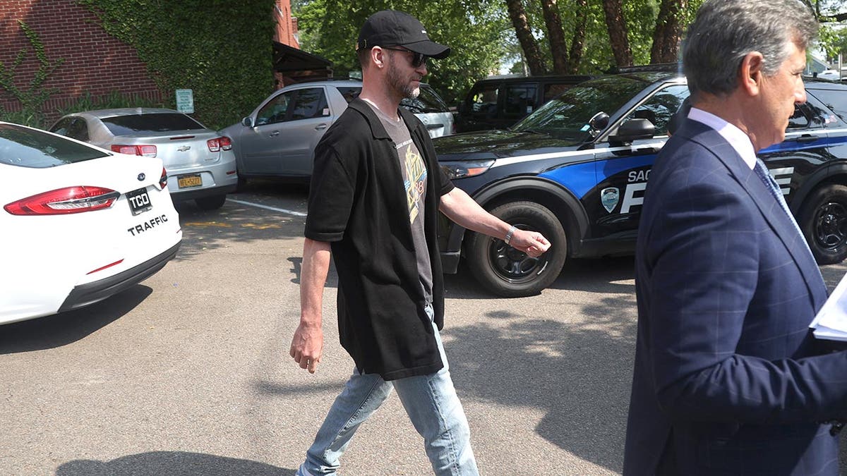 Justin Timberlake in sunglasses and a had walking out of a cops station after being arraigned on DWI charges.