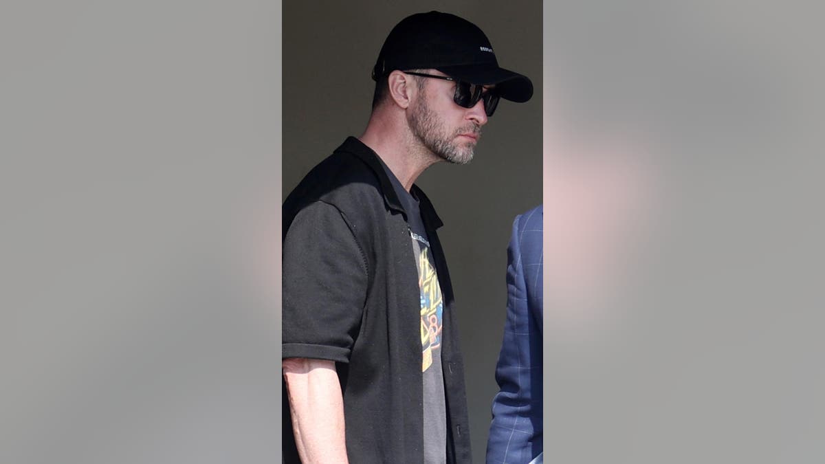 Justin Timberlake in sunglasses and a had walking out of a cops station after being arraigned on DWI charges.