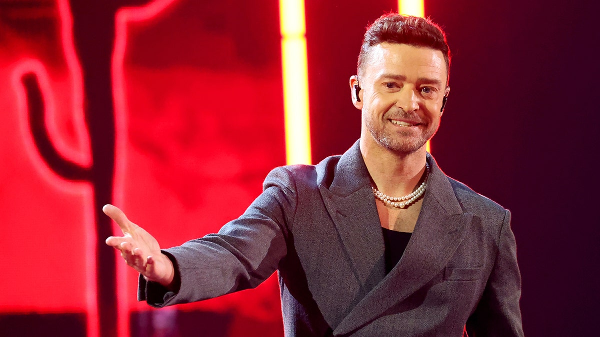 Justin Timberlake estendendo o braço no palco