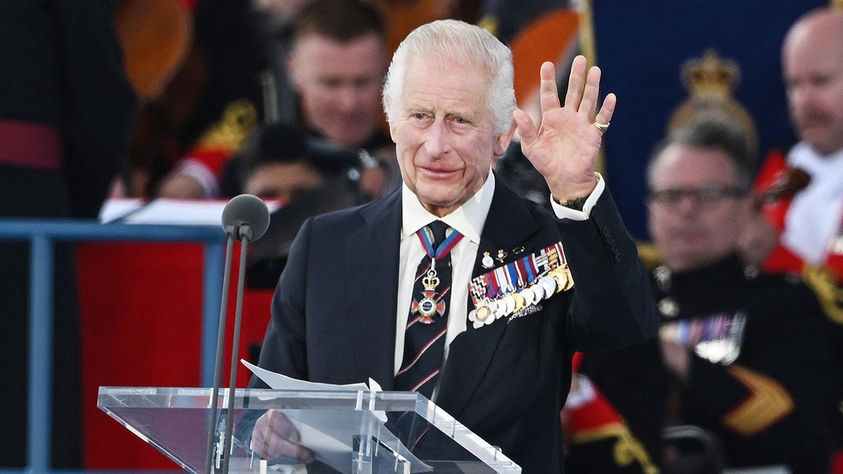 King Charles III waving to a crowd