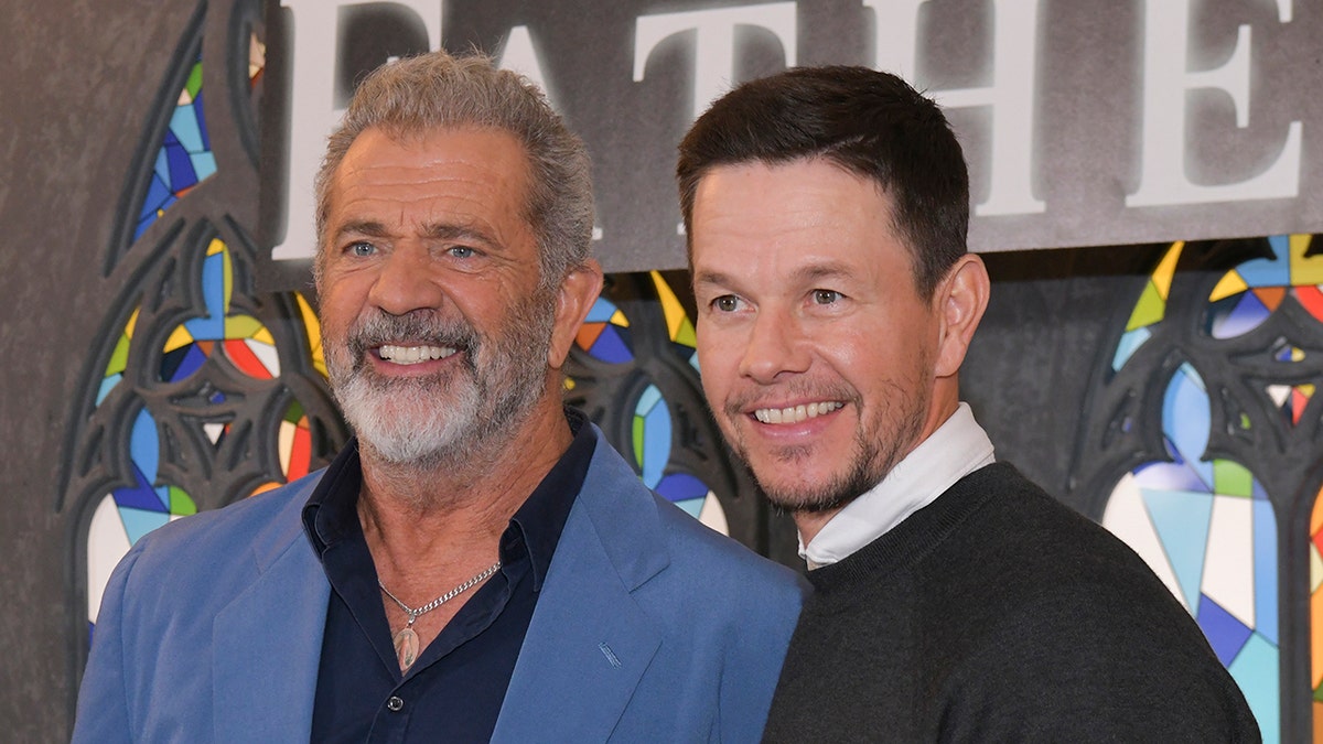 Mel Gibson and Mark Wahlberg smiling and posing together
