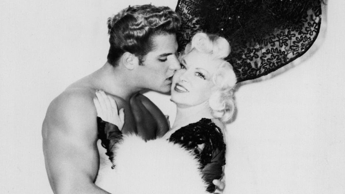 Richard DuBois beijando a bochecha de Mae West.