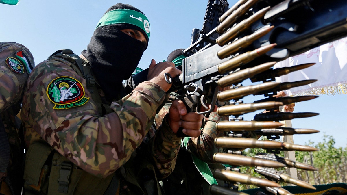 حماس کے مسلح ونگ کا ایک فلسطینی لڑاکا فوجی پریڈ میں حصہ لے رہا ہے۔