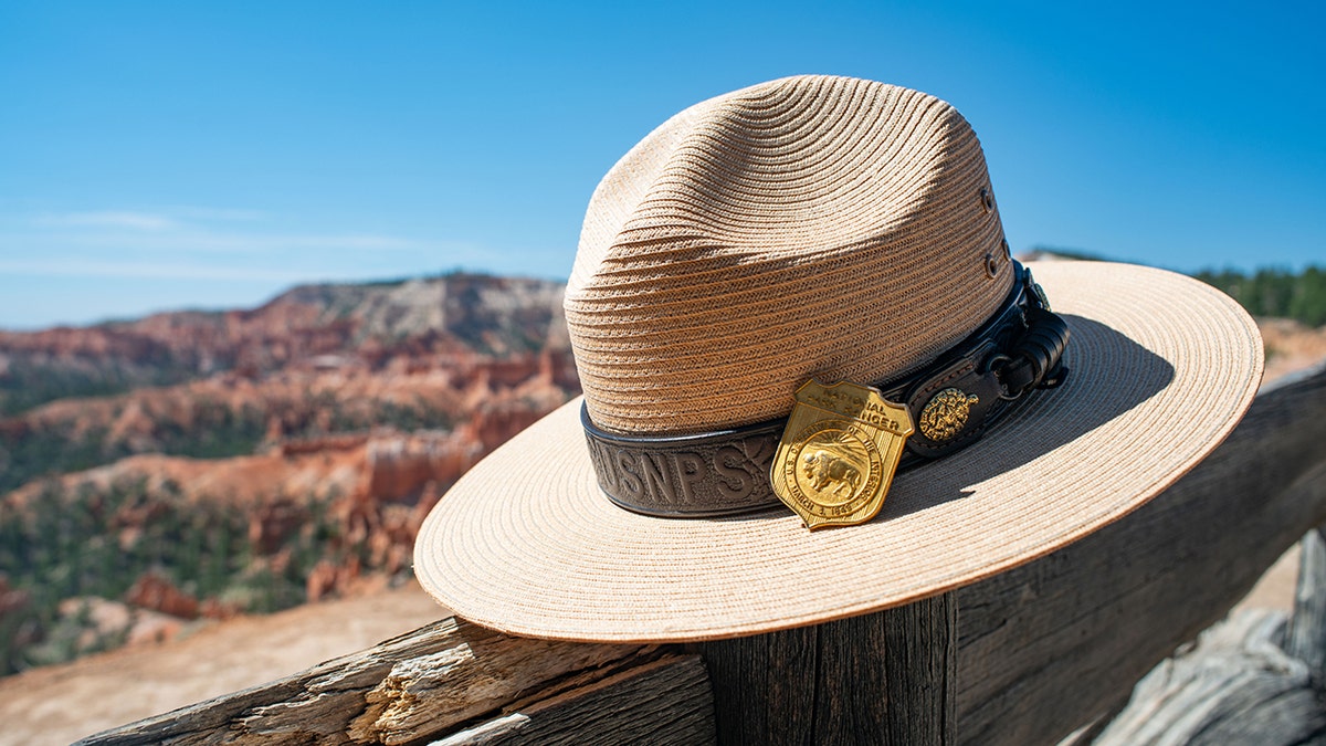 A ranger's hat sits on a fence