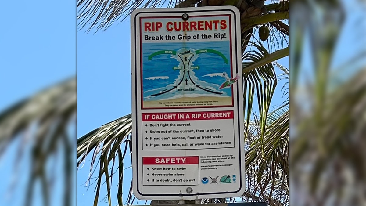 Sign at beach warning about rip currents