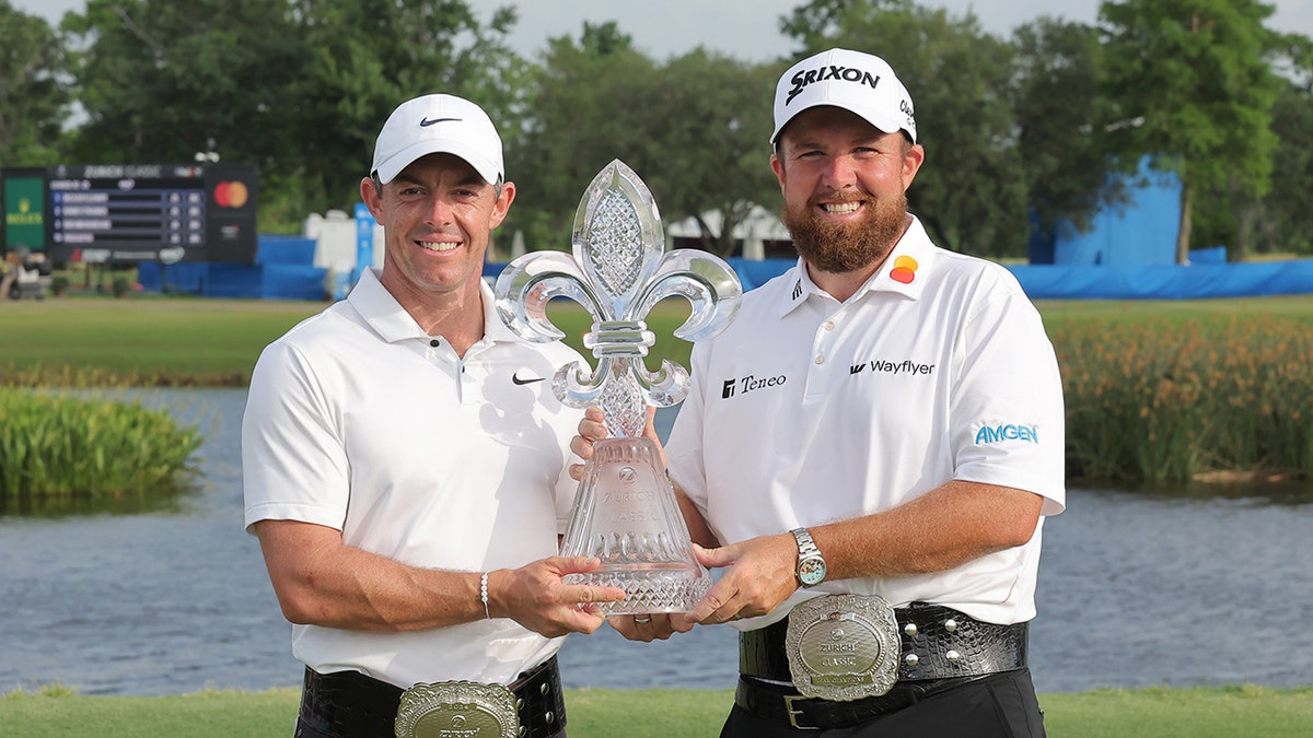 Rory McIlroy and Shane Lowry hold up trophy