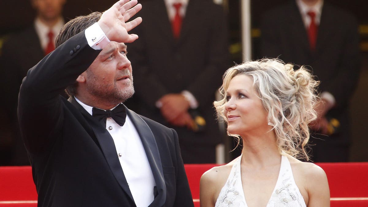Russell Crowe waves standing next to then wife Danielle Spencer