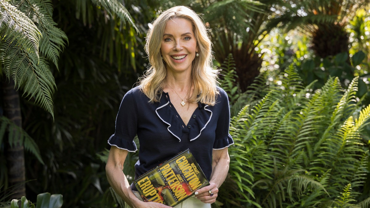 Sherri Crichton poses for a portrait holding the new novel "Eruption."