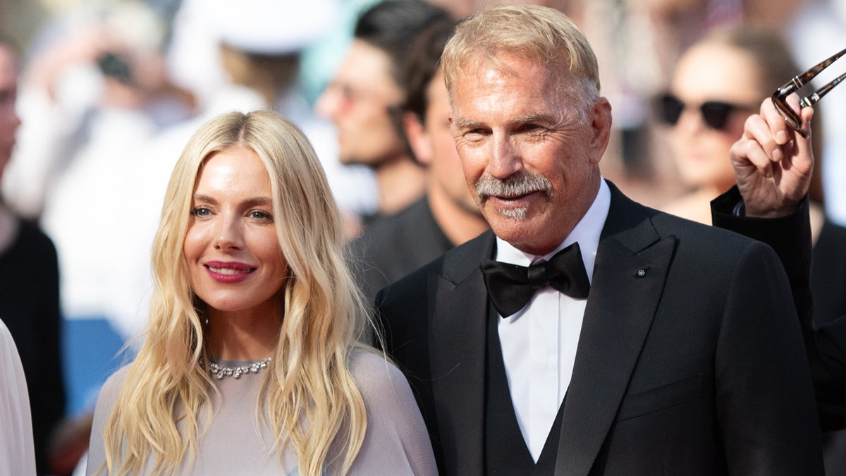 Sienna Miller and Kevin Costner pose at the Horizon premiere