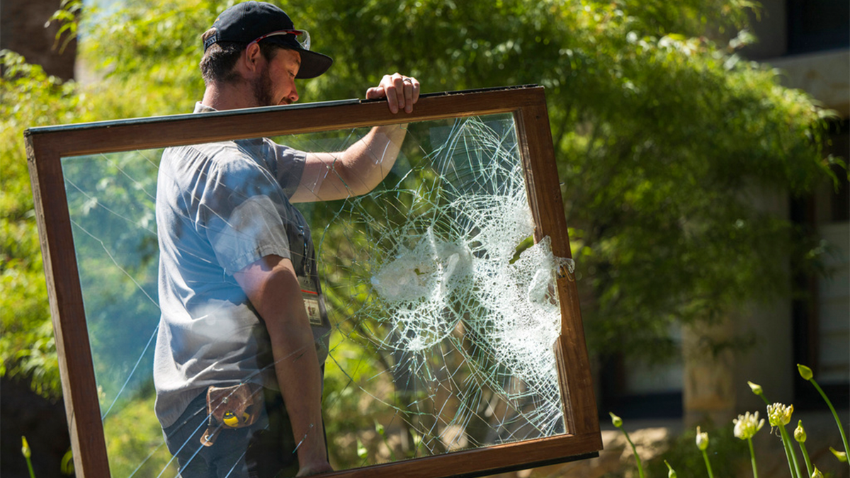سٹینفورڈ یونیورسٹی کے کارکن ٹوٹی ہوئی کھڑکی کو باہر لے جا رہے ہیں۔