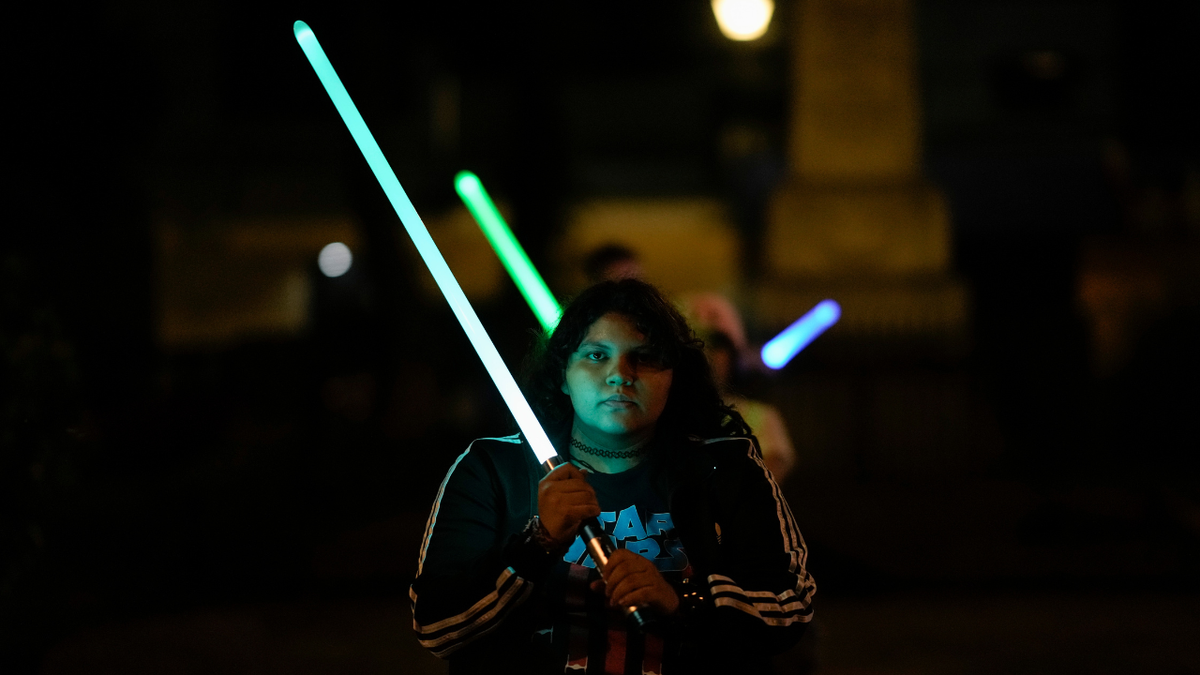 Student holding lightsaber