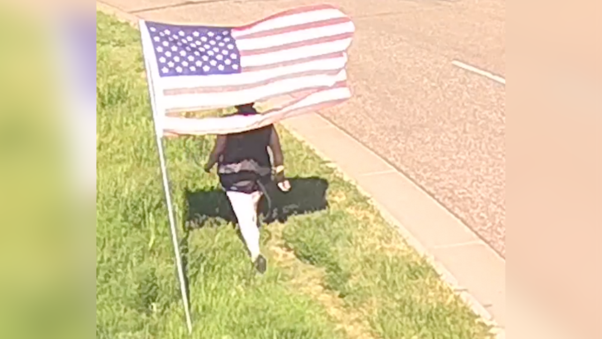 Suspect walking away after ripping American flags