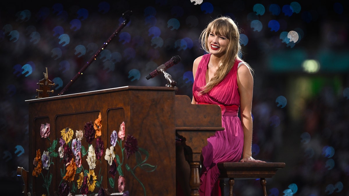 Taylor Swift sits at the piano during Eras Tour