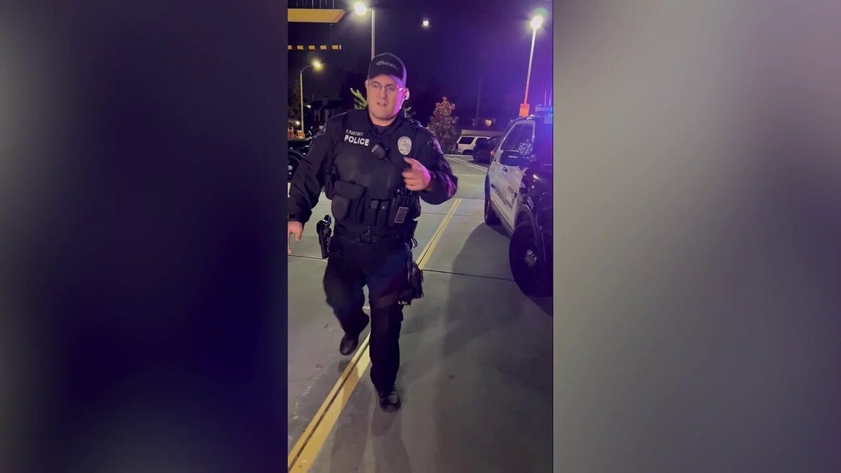 Policial se aproxima durante uma parada de trânsito à noite