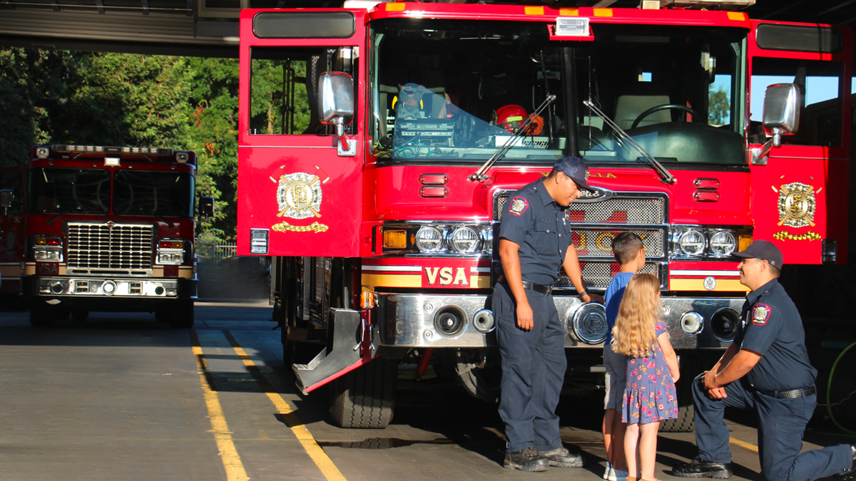 Visalia firefighters talking to children