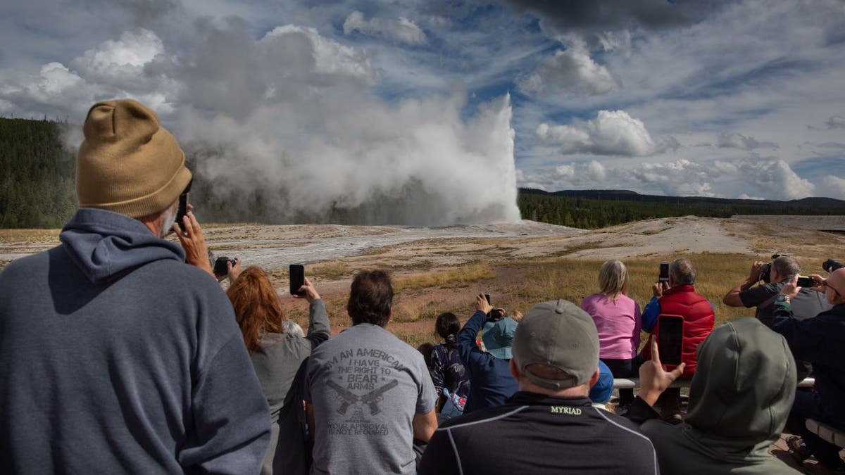 Wideshot of tourists watching geyser