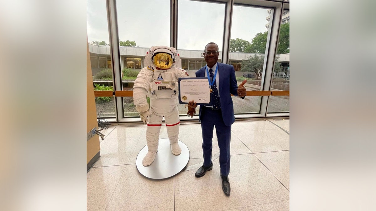 Dr.  Zubair displayed his NASA medal for Outstanding Scientific Achievement next to a statue of the astronaut.