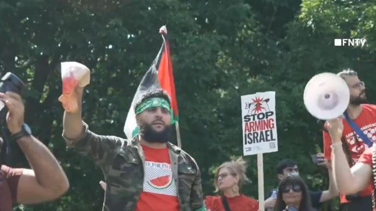 Protester wearing Hamas headband holding up bloody Biden mask