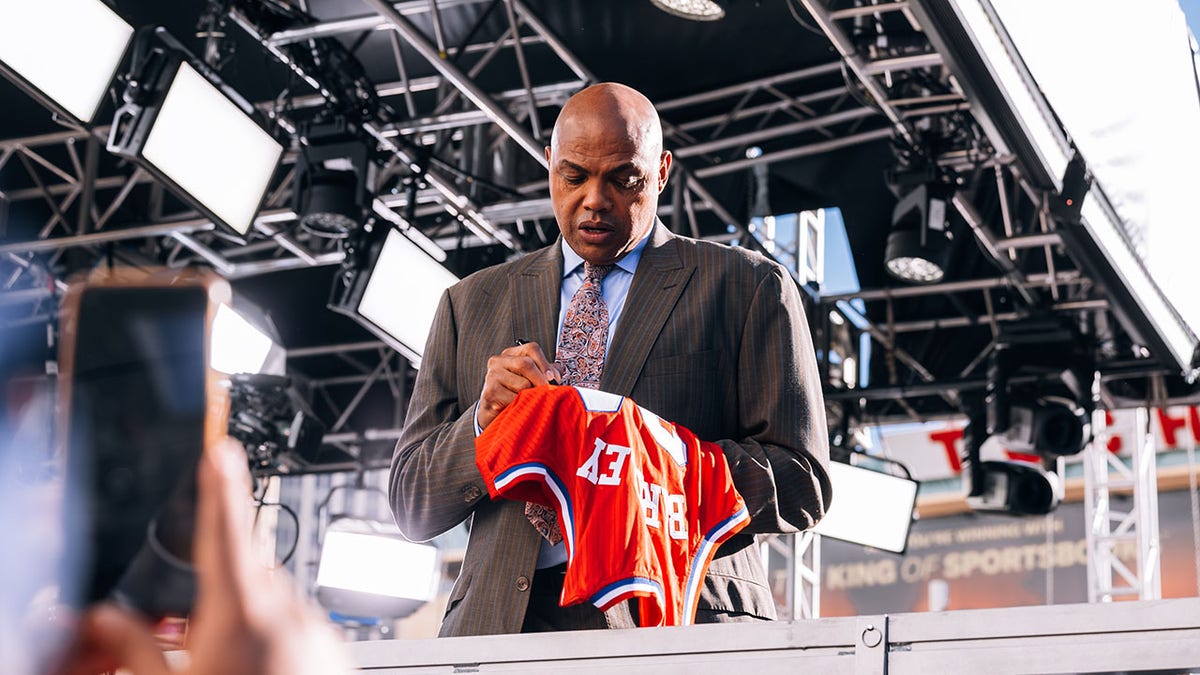 Charles Barkley signs a jersey