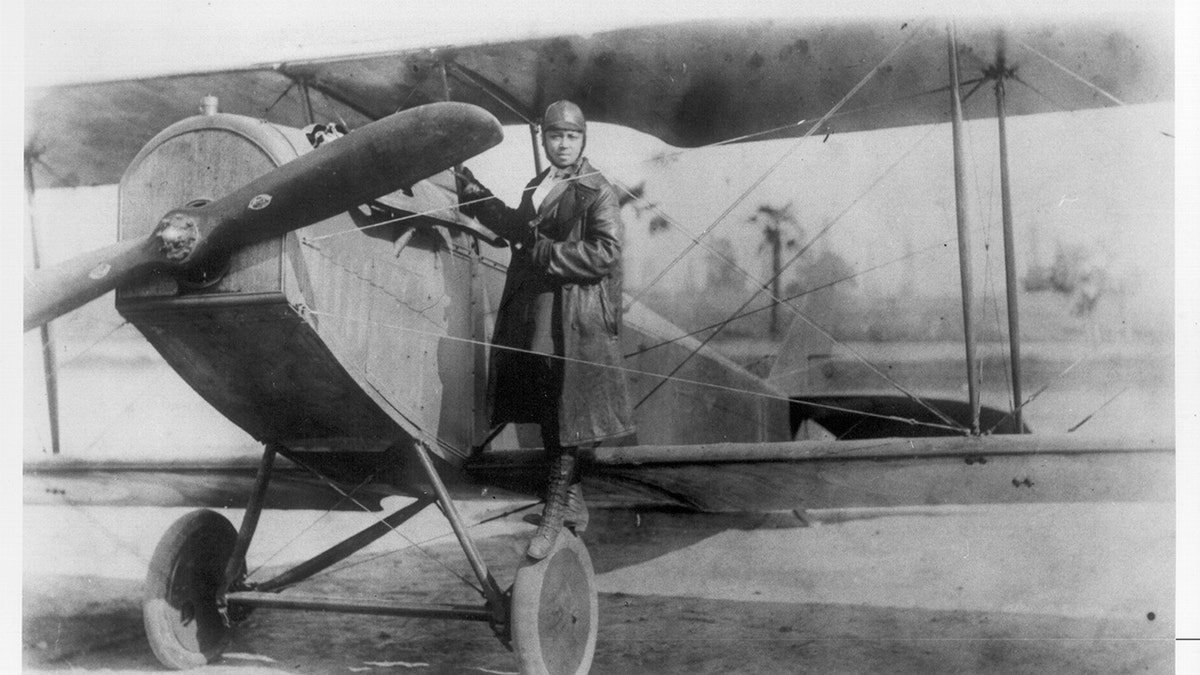 Bessie Coleman beside a plane