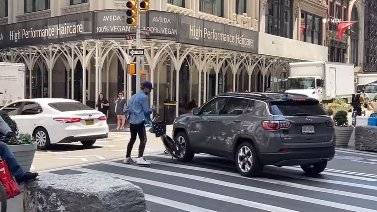 NYC cyclist puts bike in front of an SUV