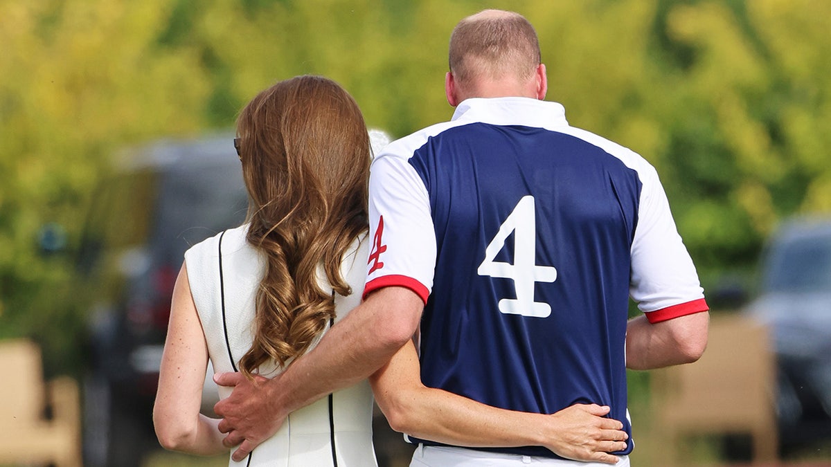 Príncipe William e Kate Middleton se abraçando de costas para a câmera
