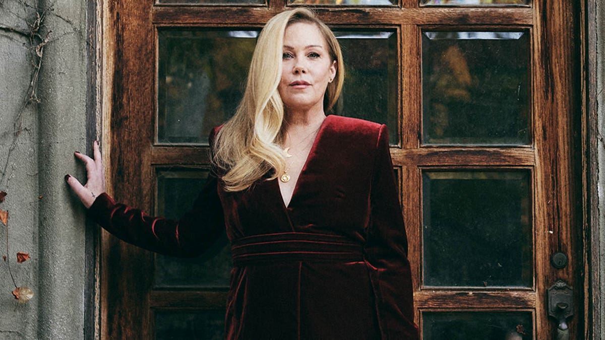 Christina Applegate looks straight at the camera in a red velvet dress