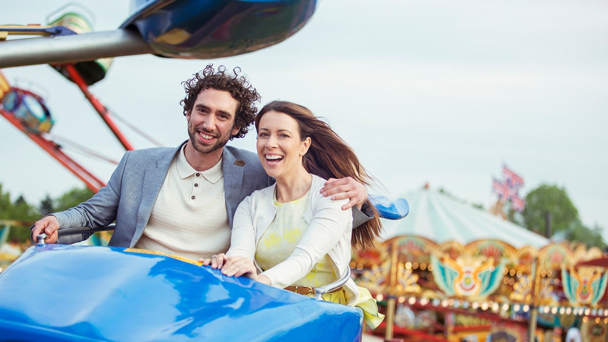 Um casal feliz passeando no parque de diversões