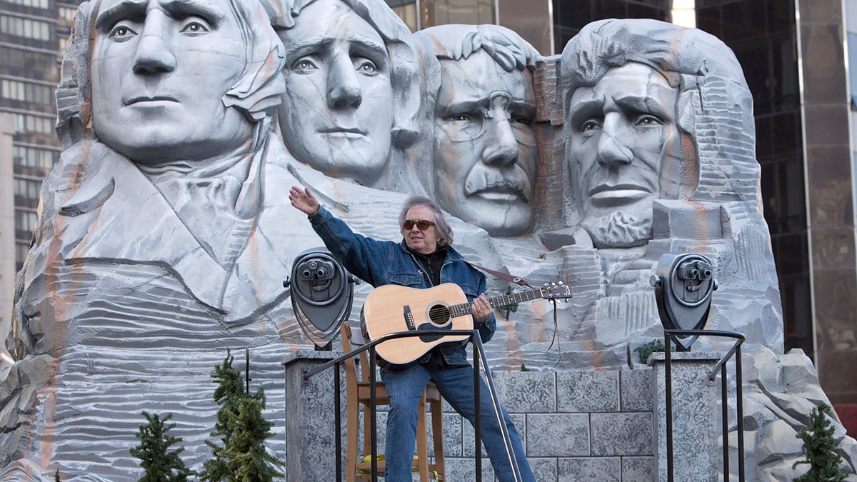 Don McLean playing on a float with Mr. Rushmore on it in the Thanksgiving parade