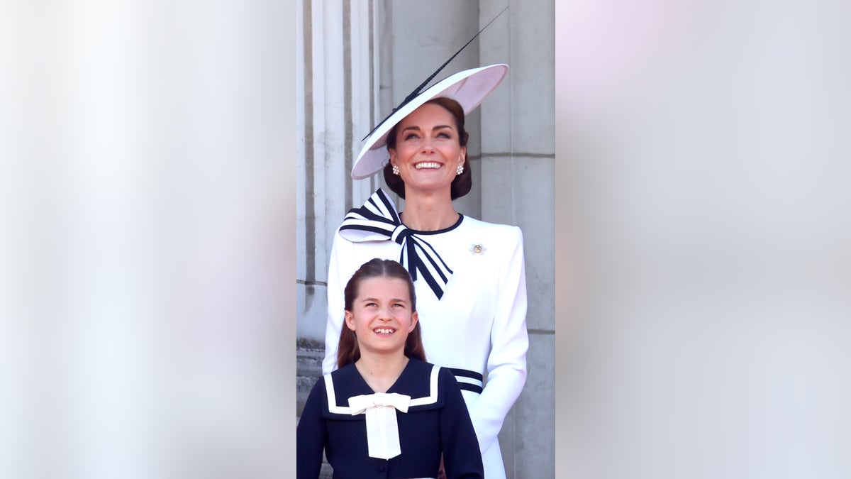 Kate Middleton looking up behind her daughter Princess Charlotte.
