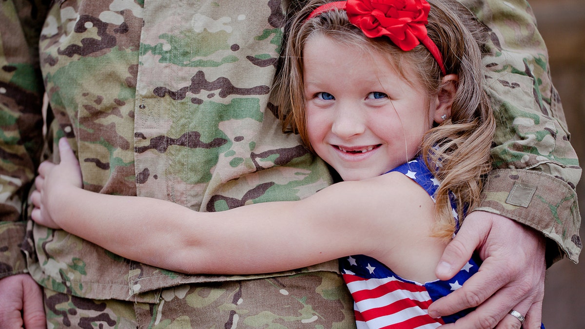 Girl hugging military member