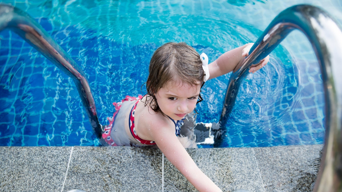 Girl climbing into pool