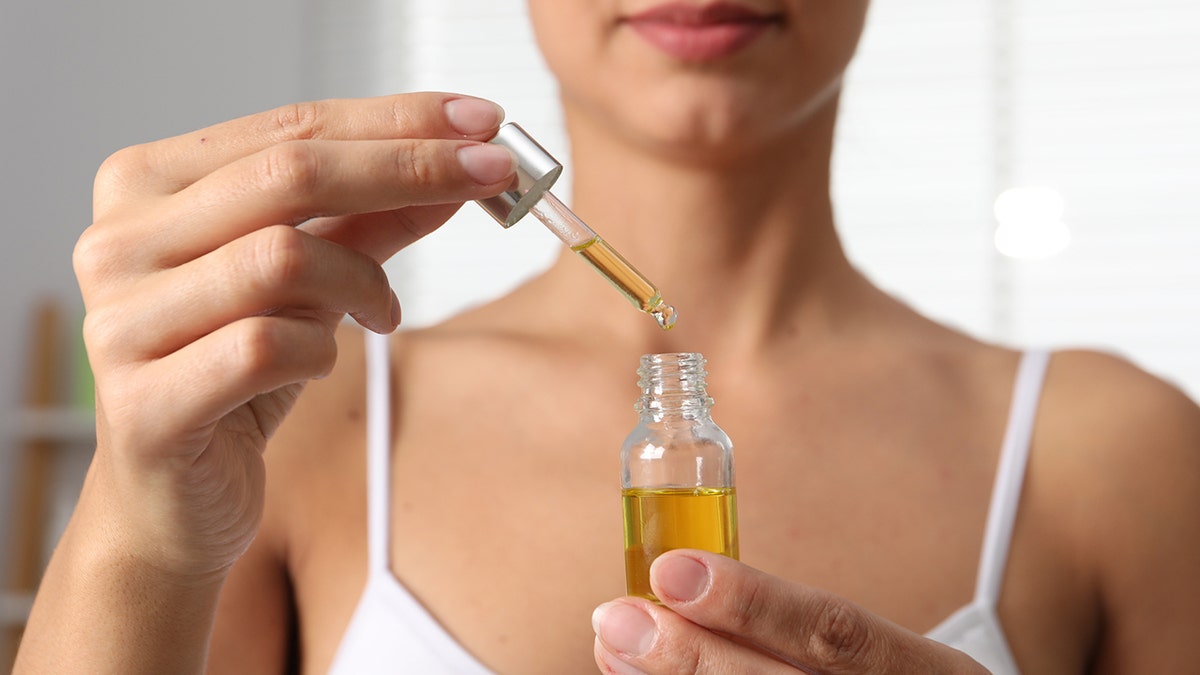 woman uses dropper with oil