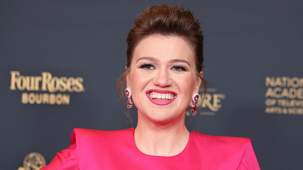 Kelly Clarkson smiles in a hot pink dress at the Daytime Emmy Awards