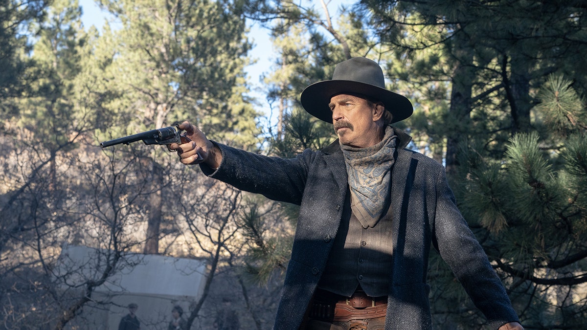 O ator Kevin Costner brande uma arma durante o set do drama country western Horizon