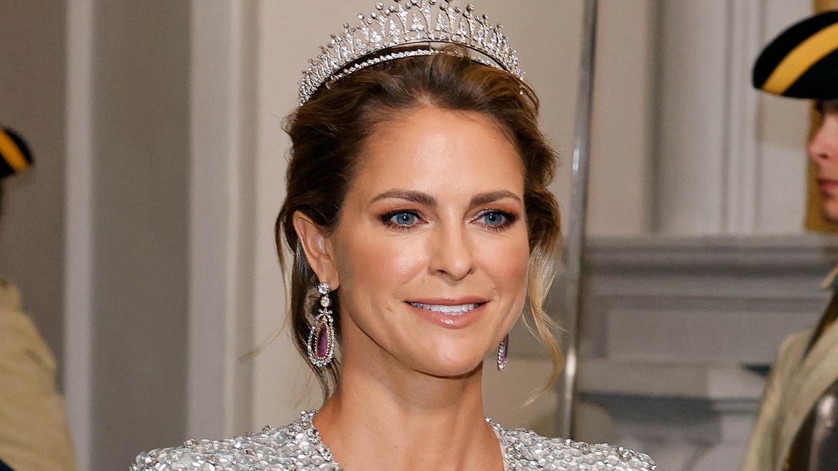 Princess Madeleine of Sweden smiling in a sparkly dress and tiara
