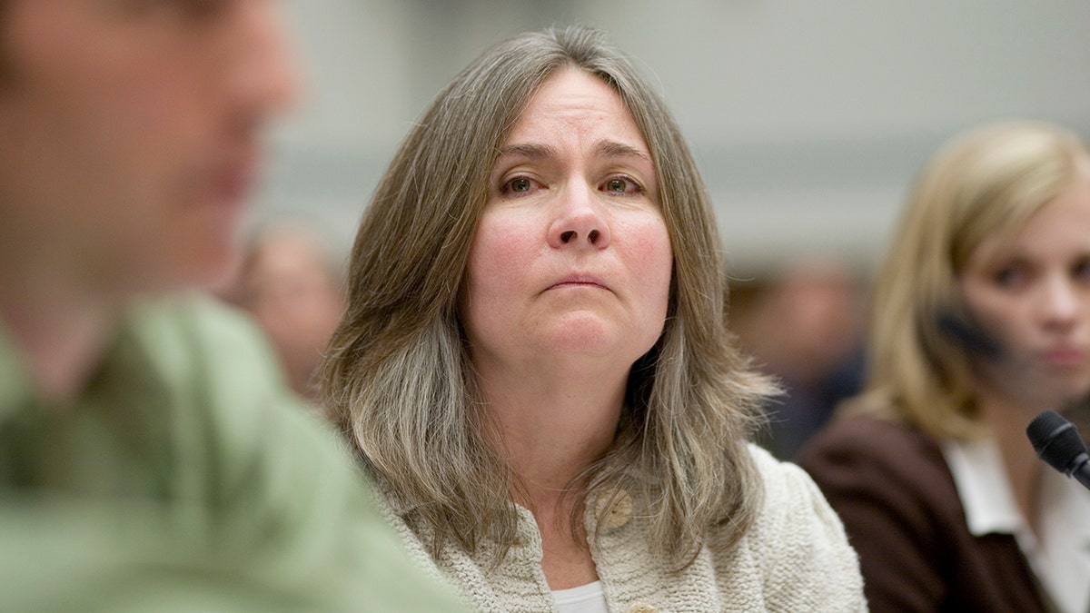 Mary Tillman no tribunal parece séria enquanto olha para alguém falando