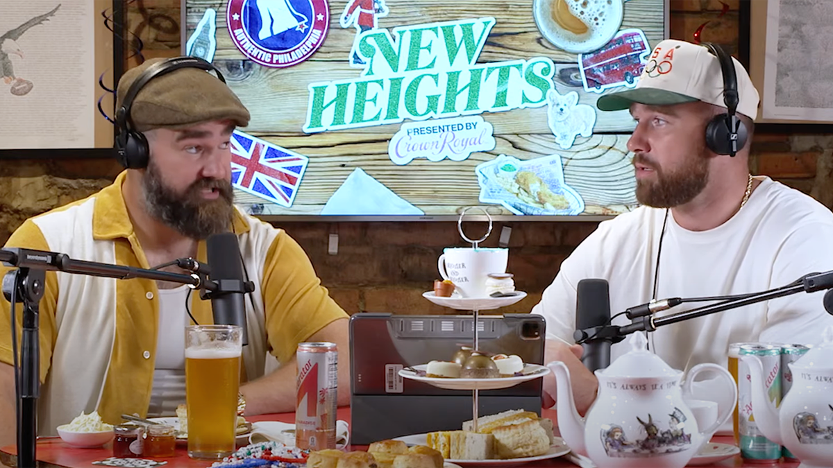 Jason Kelce in a yellow and white shirt and Travis Kelce in a white shirt talk on their "New Heights" podcast
