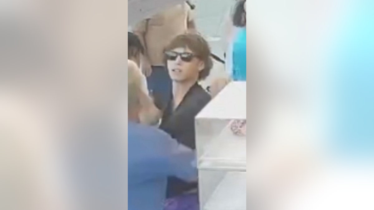 Suspect wearing sunglasses and a black shirt